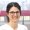Portraitfoto von Dr. Daniela Zeller, Fachzahnärztin für rekonstruktive Zahnmedizin, mit Brille und freundlichem Lächeln vor unscharfem Berner Hintergrund mit roter Markise. Sie trägt eine helle Berufskleidung.